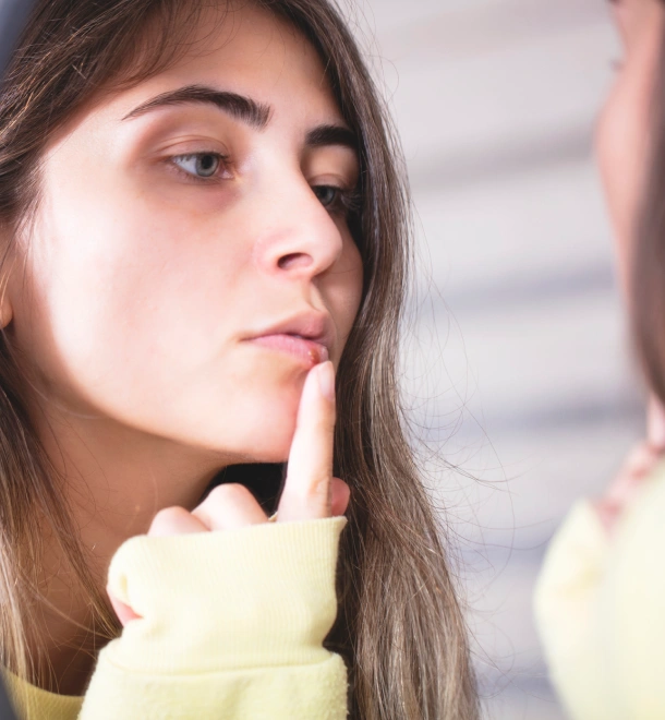 Young woman with thoughtful expression, hand to chin, considering dental care options indoors.