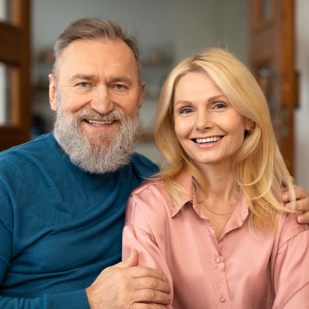 Two smiling dental professionals posing together in a clinical office setting.